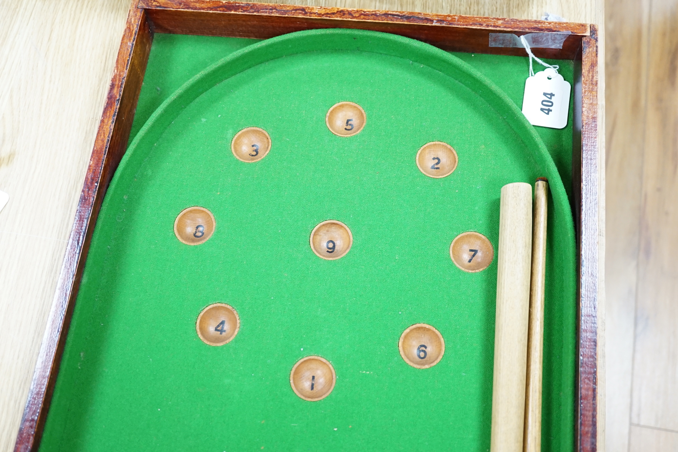 A bagatelle board, balls and cues, 108cm in length